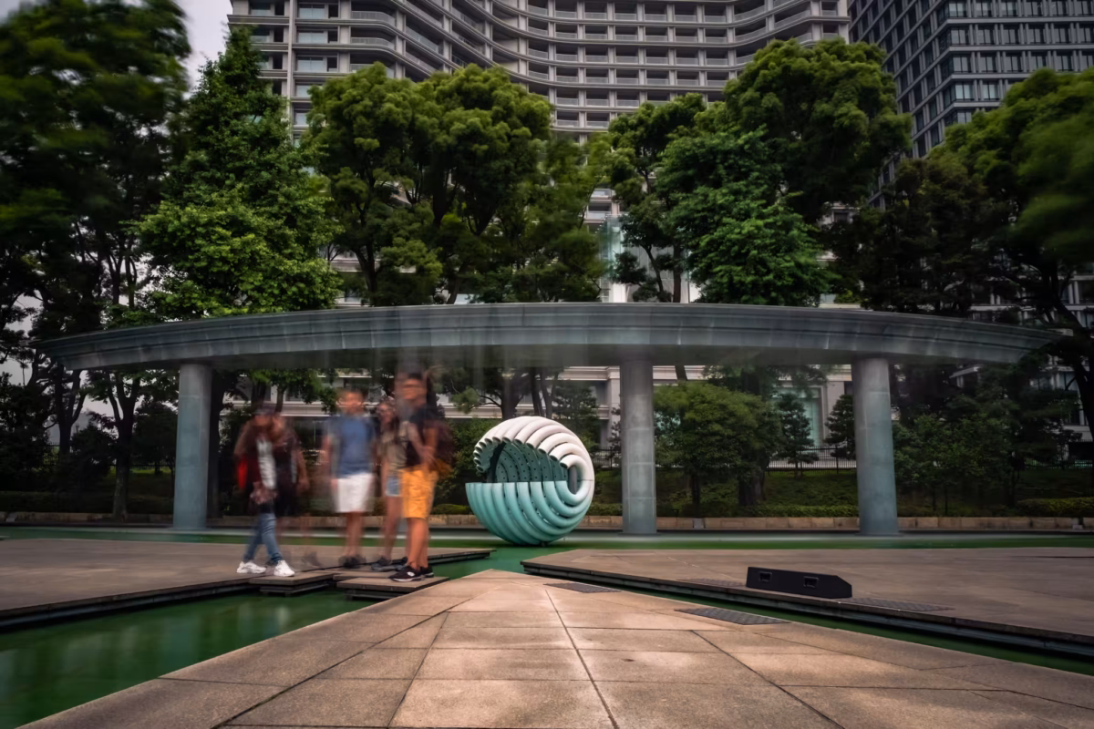 Blurry people next to the Wadakura Fountain Park waterfall.