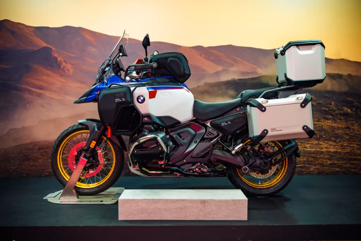 A BMW GS with panniers on a display with painted desert background.