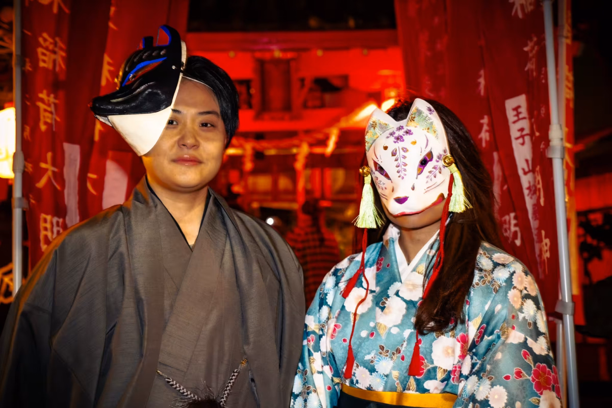 Japanese couple wearing fox masks and kimonos.