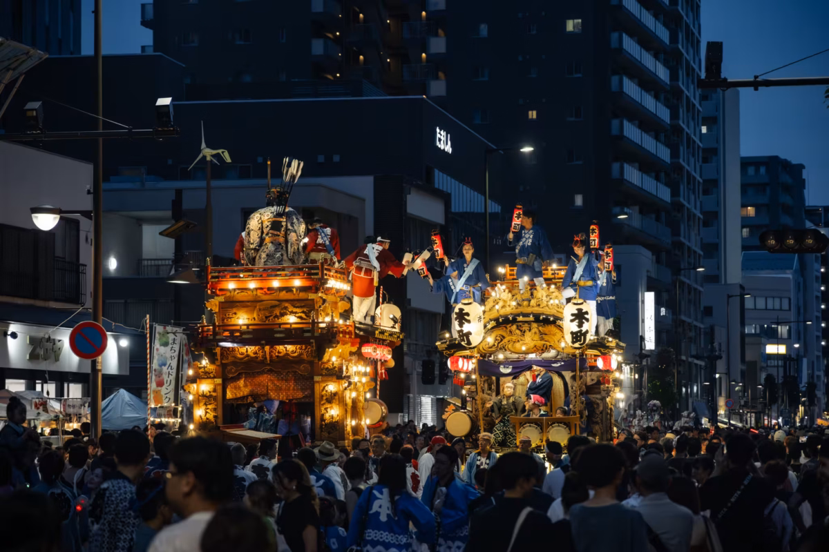 Two floats meet in a street at night.