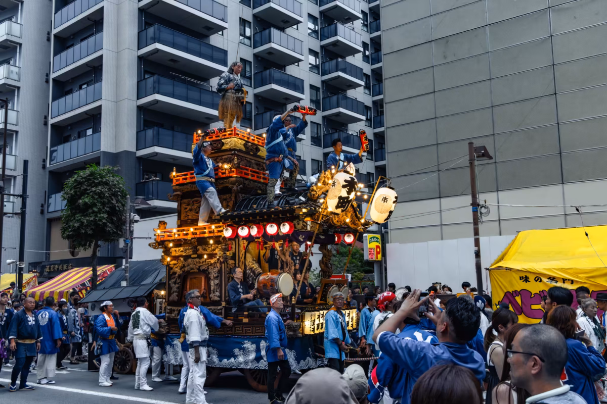 People in traditional clothes wait to move a large float.