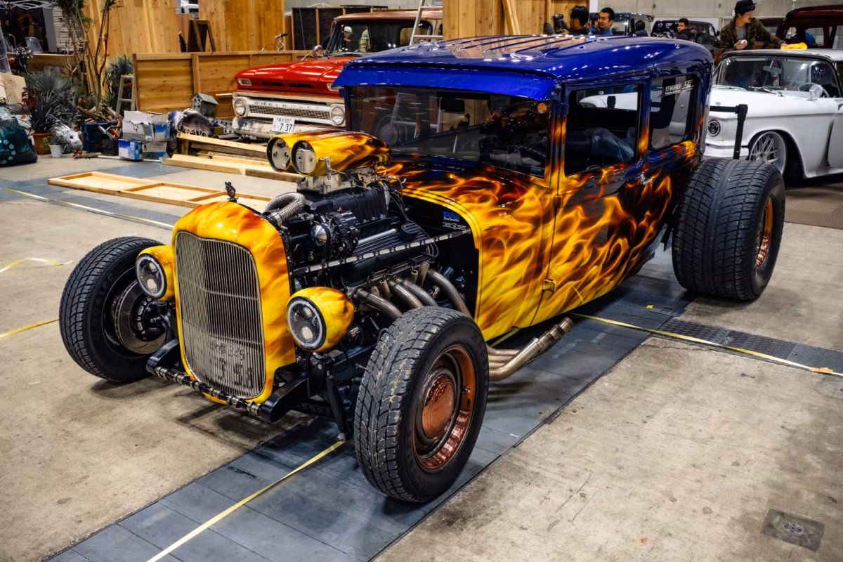 An engine exposed Ford Model A hot rod at a car show.