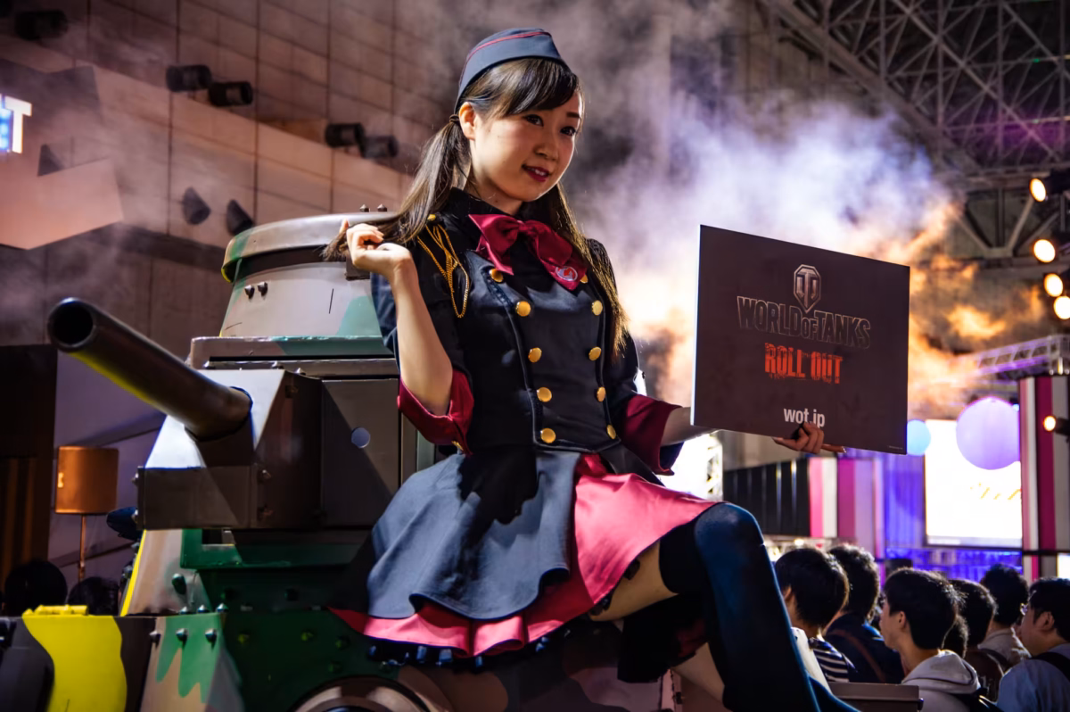 A model sits atop a Japanese light tank at Tokyo Game Show 2016.