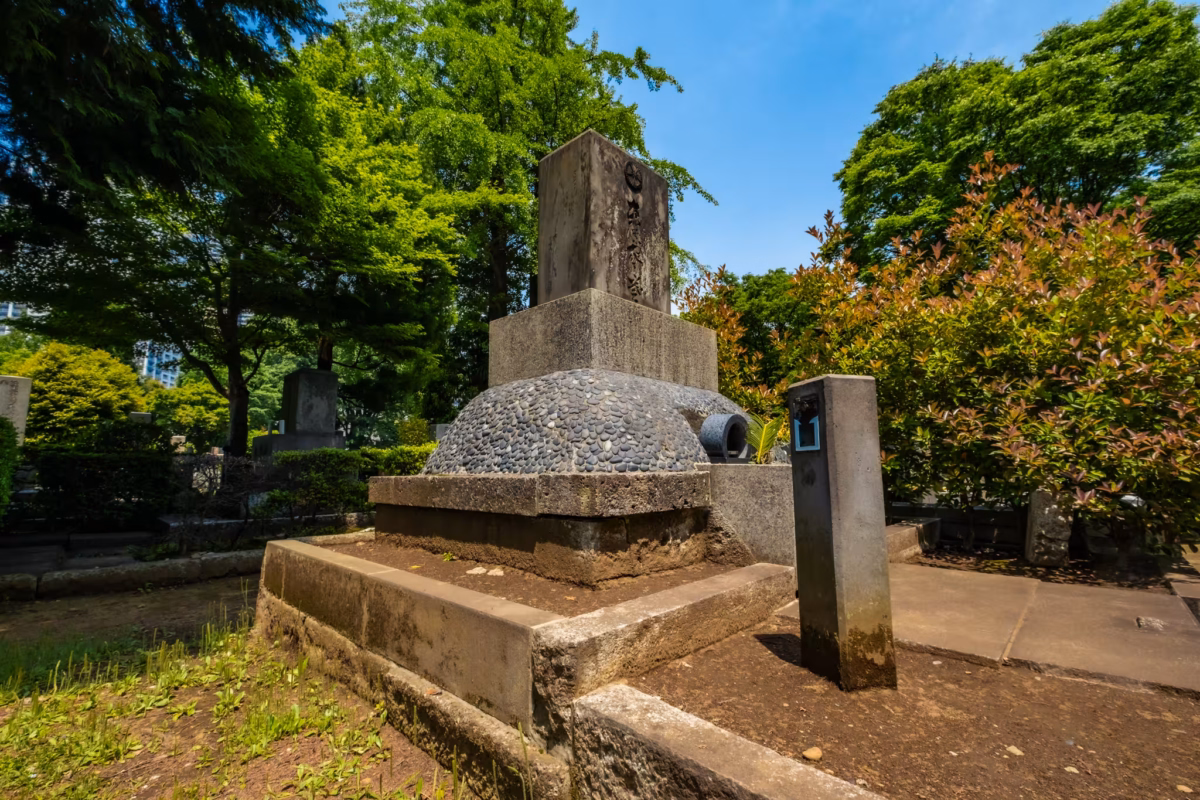 The grave of Hideki Tojo with trees behind at Zoshigaya Cemetery.
