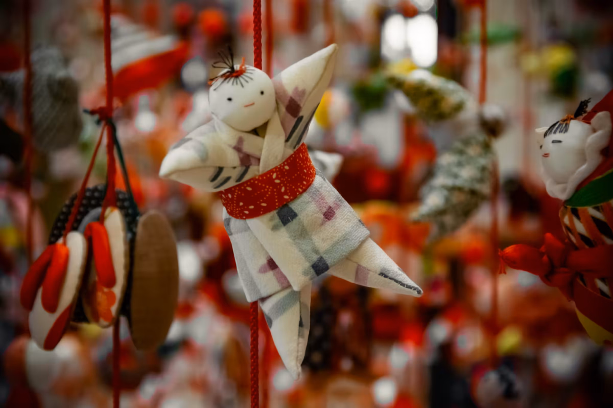 A man Hina doll hanging from a cord.