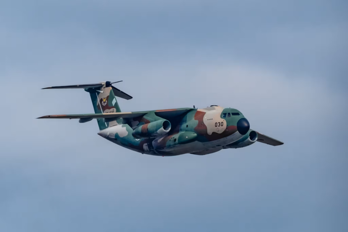 A Kawasaki C1 flying in a cloudy sky.