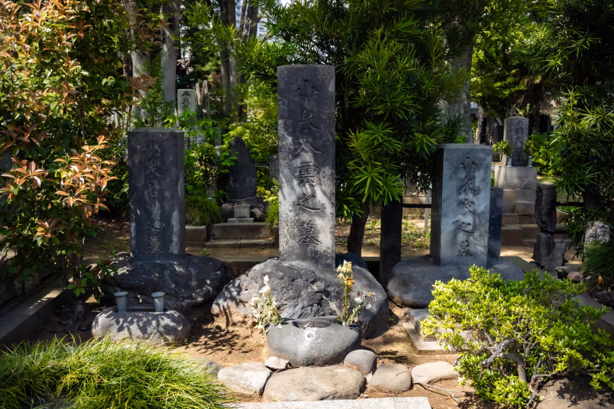 The graves of Lafcadio Hearn and his family, sit in the shade of trees.