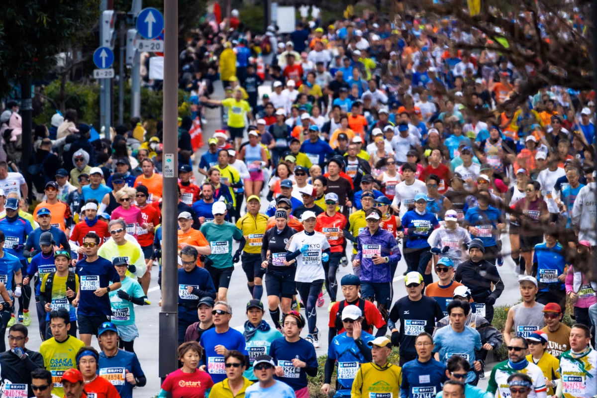 Hundreds of marathon runners on a Tokyo street.