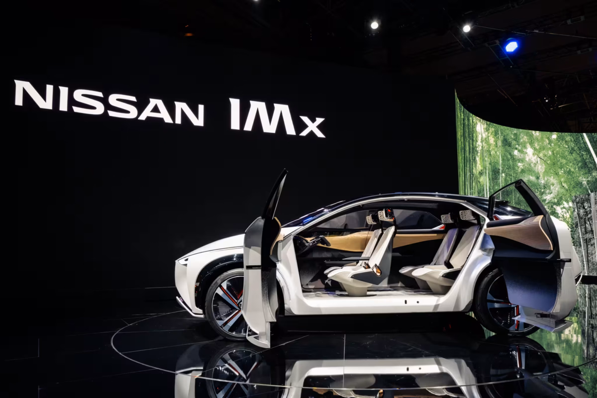 A white Nissan IMx concept car against a black background.