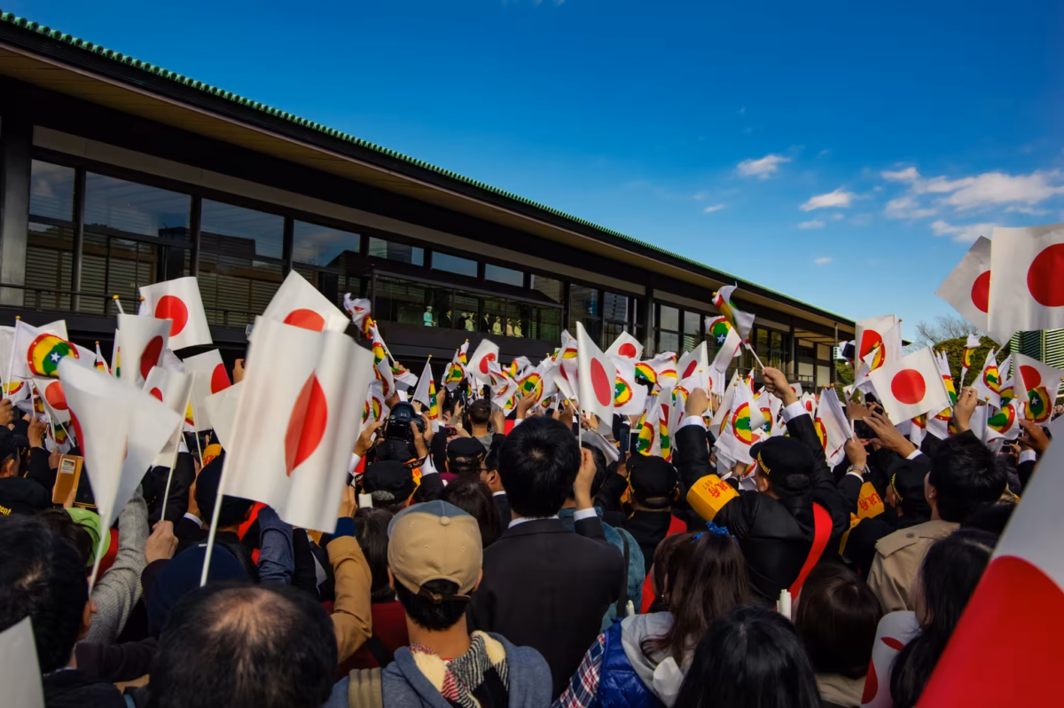 A huge crowd wave Japanese flags on the balcony of Chowaden Hall at the Imperial Palace.