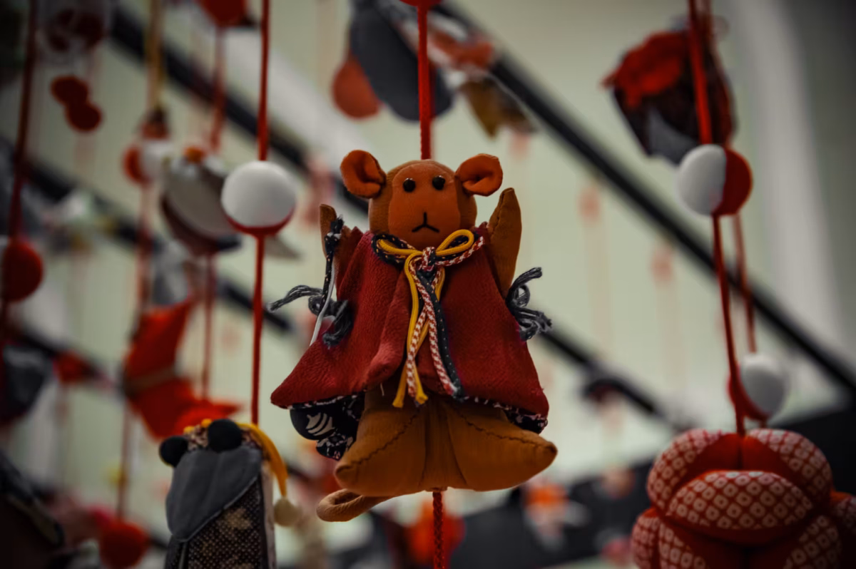 A bear Hina doll hanging on a cord.
