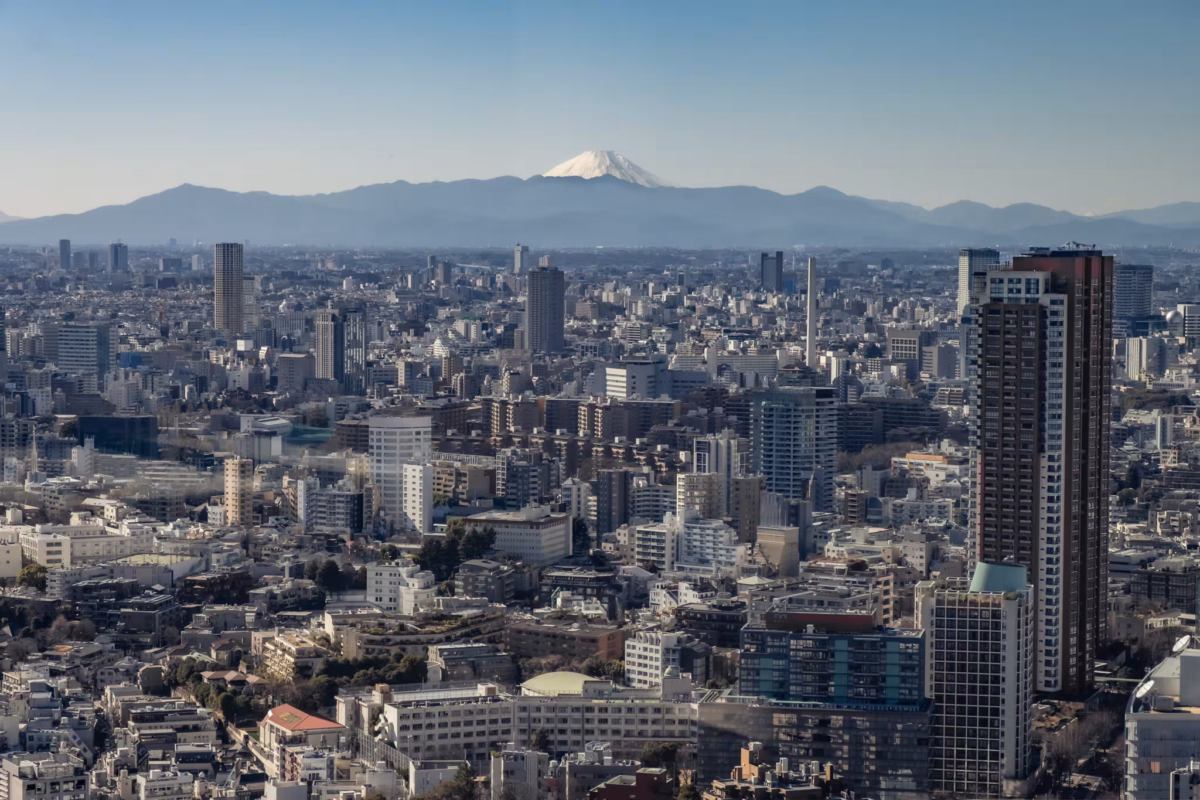 Mount Fuji stands above the concrete jungle on a cloudless day.