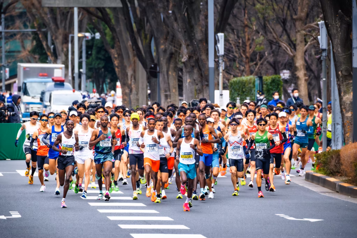 A pack of marathon runners take a corner during a race.
