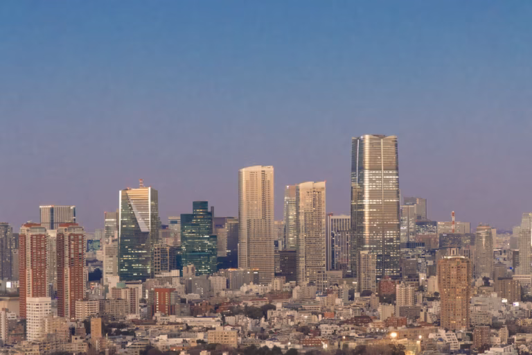 Toranomon Hills Mori Tower and the Tokyo skyline at twilight under a soft lavender and blue sky.