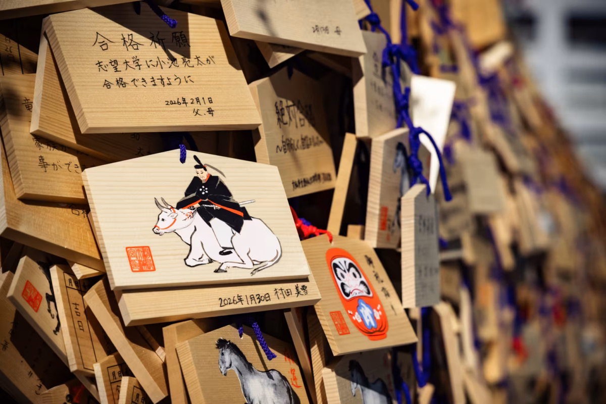 Wooden prayer plaques cover a rack at a shinto shrine.