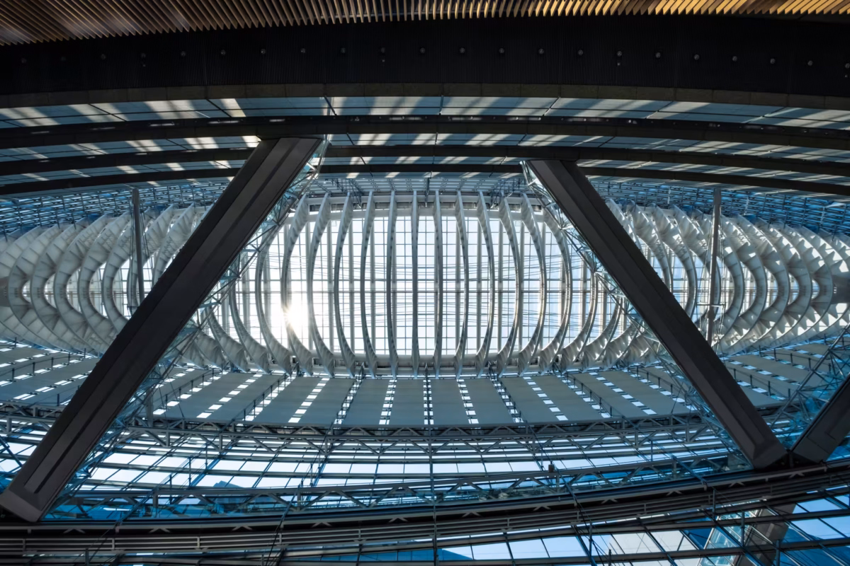 Low-angle view of the iconic ribbed glass and steel ceiling structure at the Tokyo International Forum.