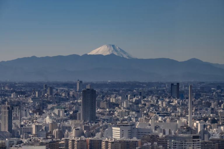 A snow-capped Mount Fuji sits above the Tokyo concrete jungle.