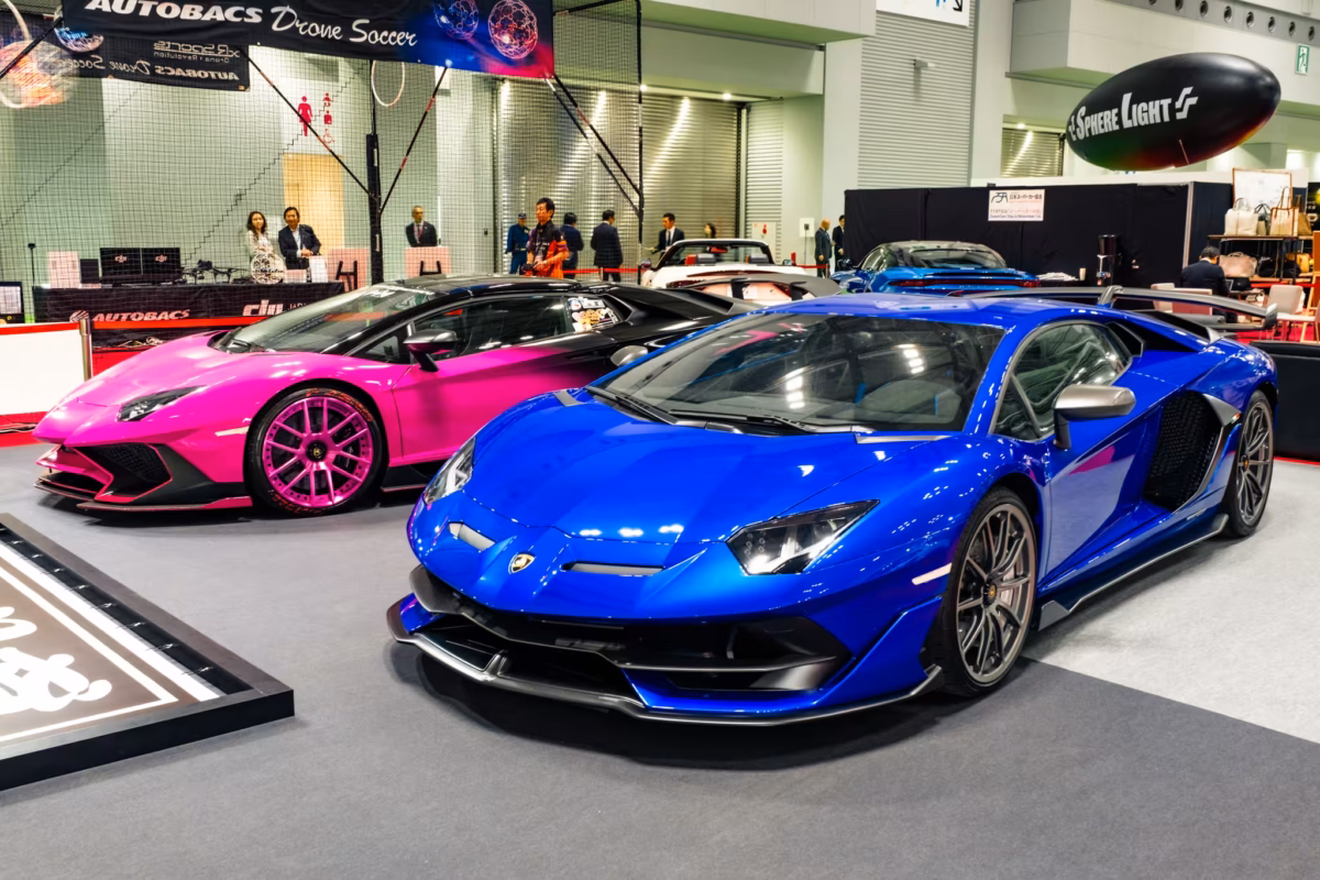 A blue lamborghini with a pink one behind.