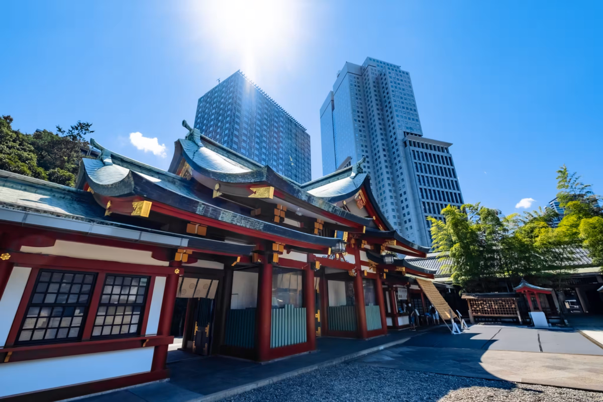 Small white kitsune (fox) figurines with red ears and Japanese calligraphy at Hie Shrine.