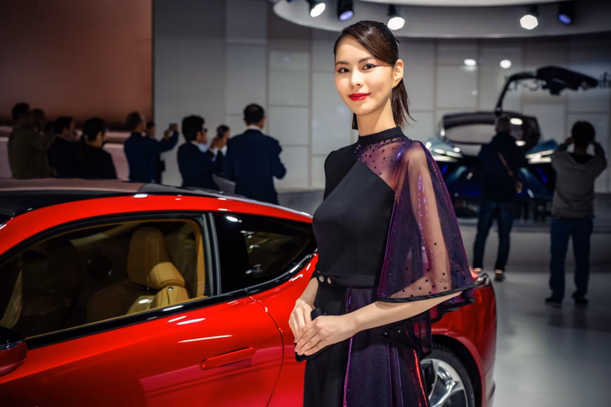 A Japanese car companion stands next to her car at Tokyo Motor Show 2019.