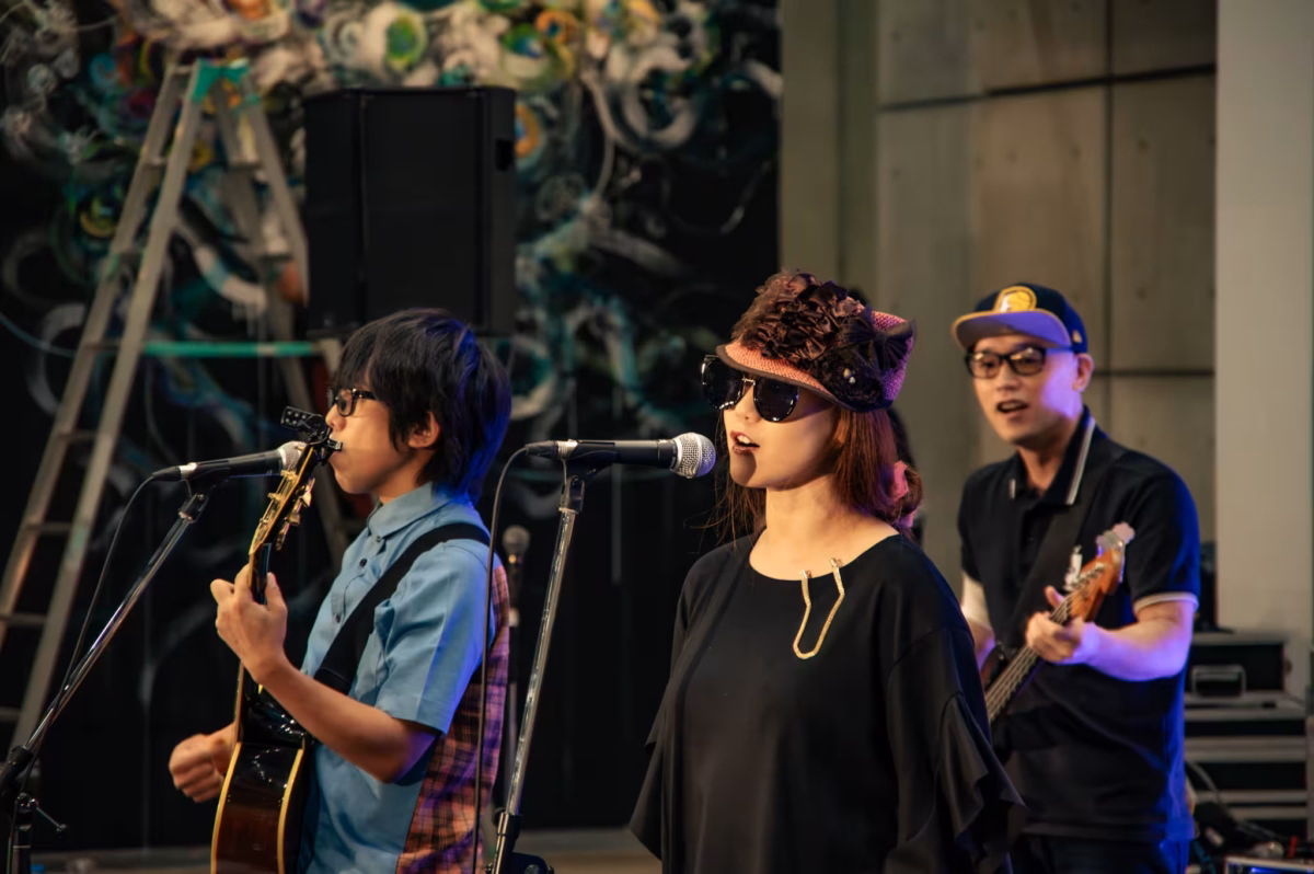 Three Japanese musicians play music indoors.