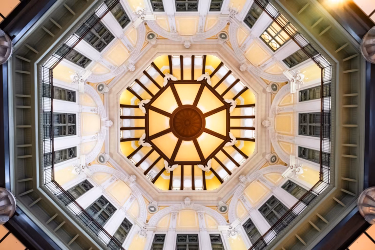 Tokyo Station Marunouchi North Exit domed ceiling with yellow panels, white reliefs, and radial dark beams.
