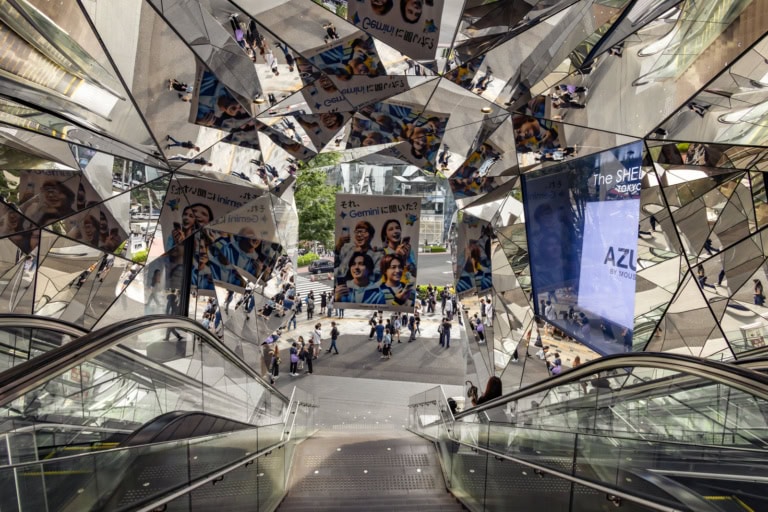 The kaleidoscopic mirrored entrance of Tokyu Plaza Omotesando reflecting a busy street scene below.