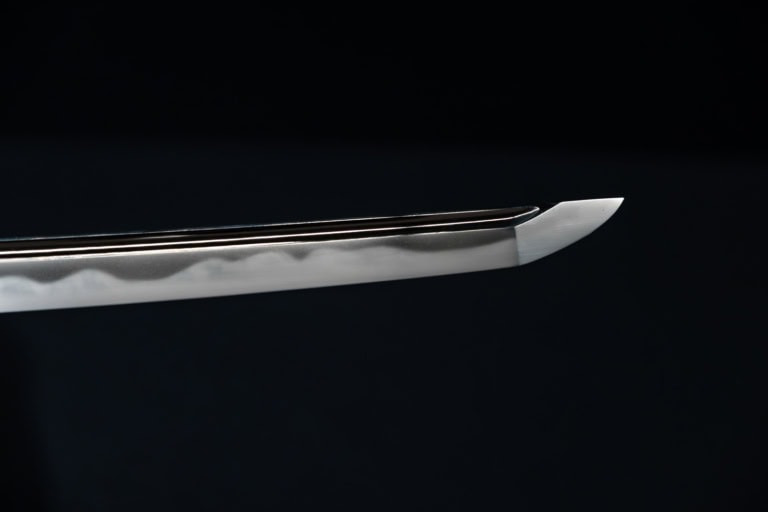 Detail of a polished katana tip with a wavy hamon line at the Japanese Sword Museum.