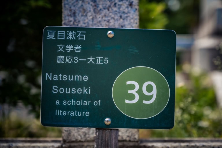 Close-up of a green sign for Natsume Soseki, "a scholar of literature," with the number 39 in a circle.