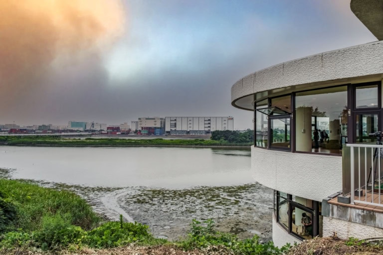View of wetlands and industrial warehouses from the observation center at Tokyo Port Wild Bird Park.