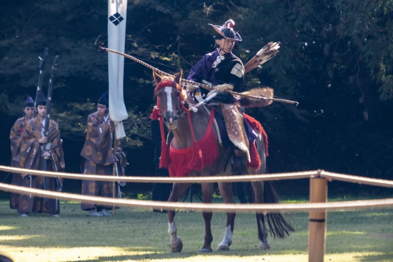 A traditional archer on horseback prepares to shoot a bow during a yabusame demonstration.