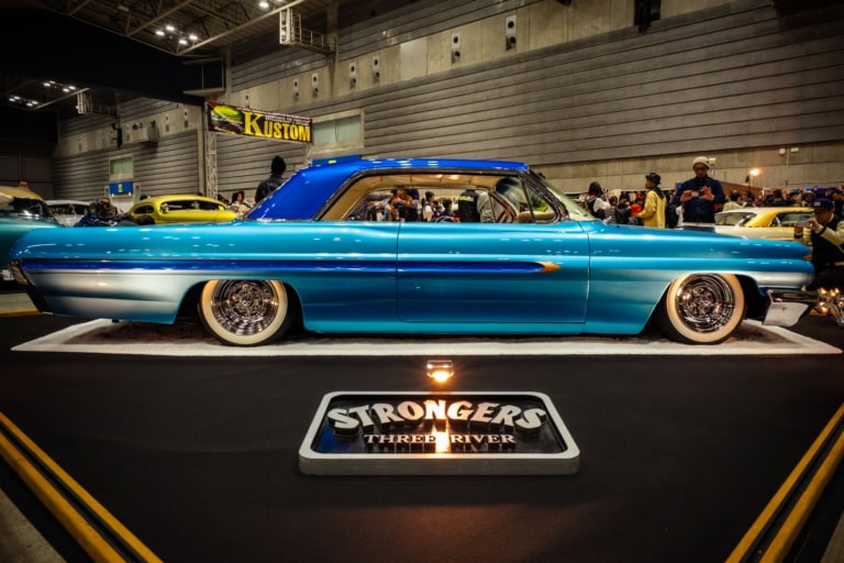 Sleek 1962 Pontiac Grand Blue at the 28th Yokohama Custom Hot Rod Show, showcasing custom two-tone paint and chrome rims.