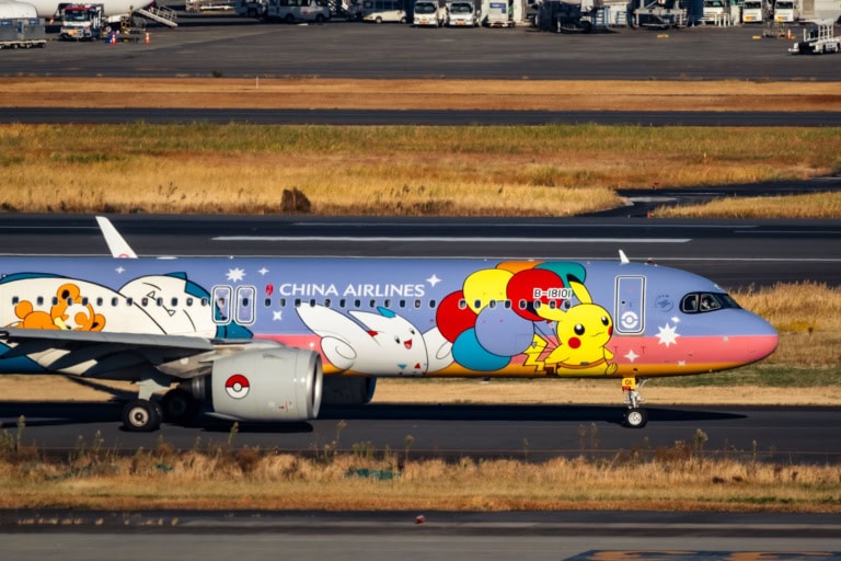A China Airlines Airbus A321neo featuring a Pokémon livery with Pikachu taxis on a sunlit airport runway.