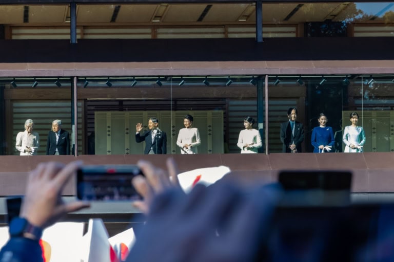 The Japanese Imperial Family appears on a balcony for a New Year Greeting as spectators take photos with phones.