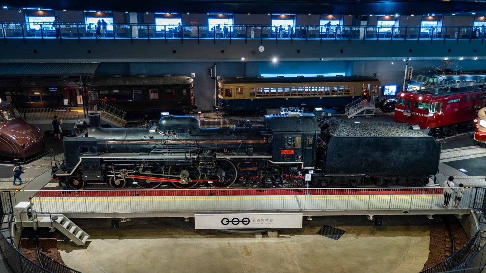 A black steam locomotive is prominently displayed on a turntable at The Railway Museum, viewed from an elevated perspective.