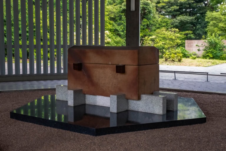 Chidorigafuchi National Cemetery ceramic coffin with background trees and pavilion columns.