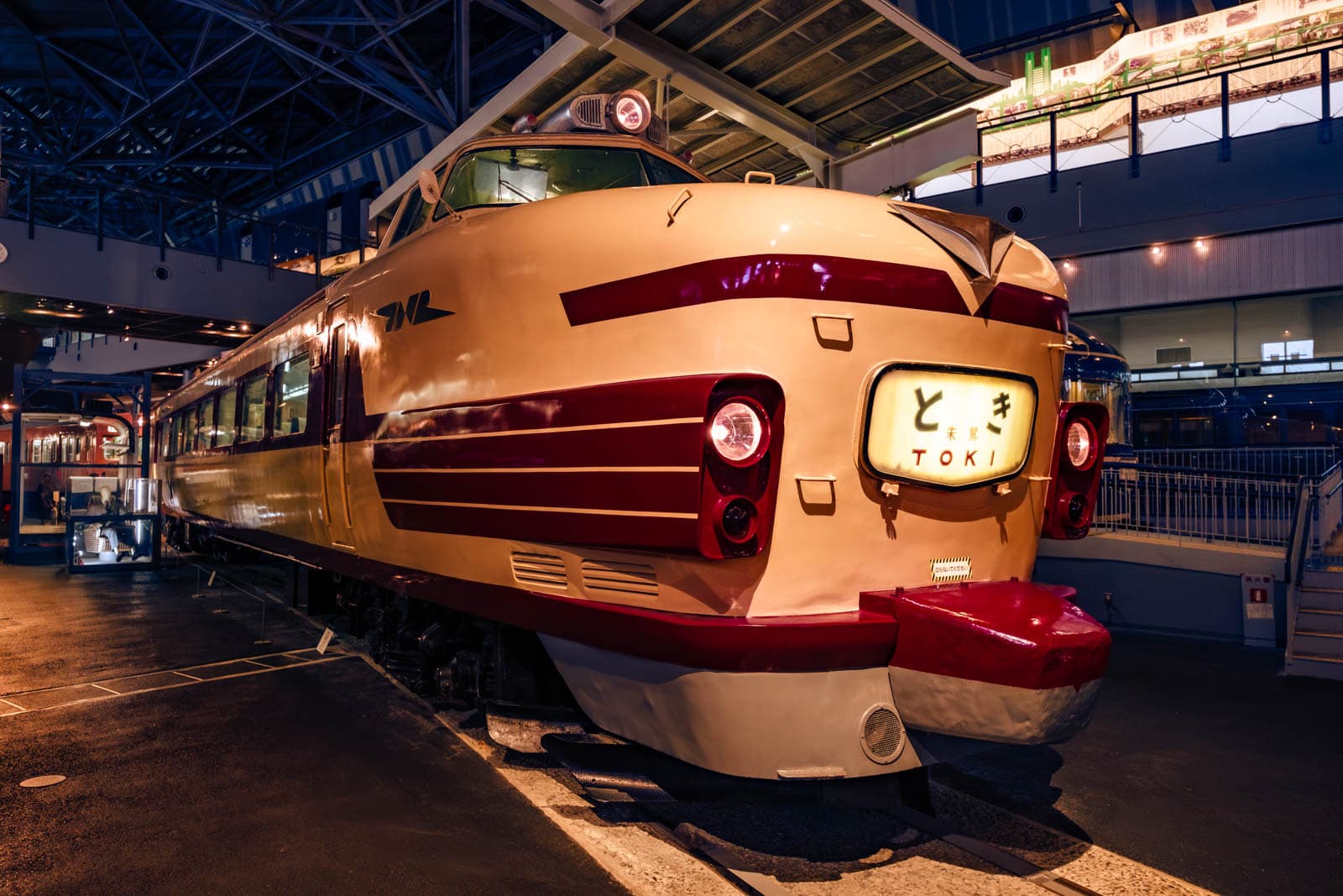Class Kuha 181 electric railcar on display indoors, featuring cream and red livery and a "Toki" train sign.