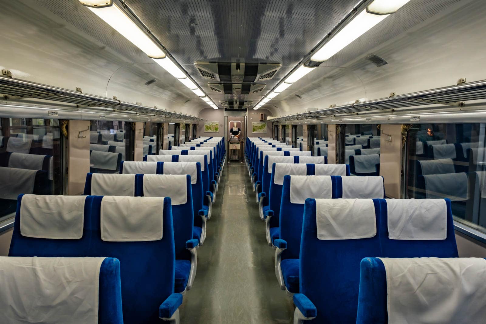 Interior of the Class Kuha 181 train showing blue passenger seats with white headrest covers lining a center aisle.