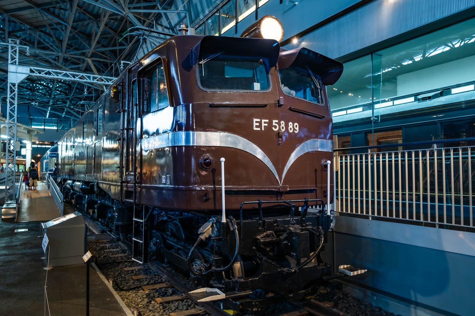 Brown EF 58 89 electric locomotive on display indoors at a museum behind a railing.
