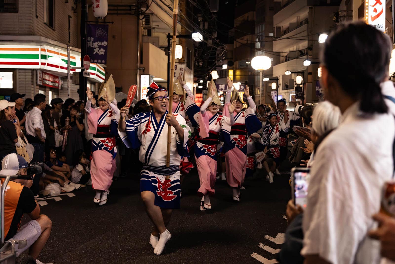 Performers in traditional attire dance on a street at night during the Hatsudai Awa Odori.