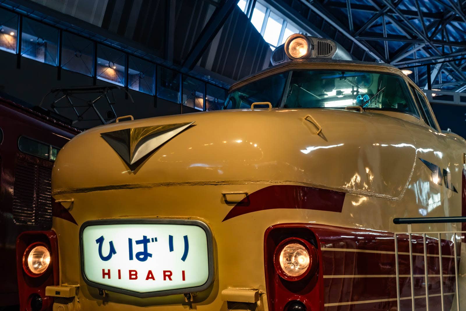 Cream and red Kuha 481 train with a "Hibari" sign on display indoors.