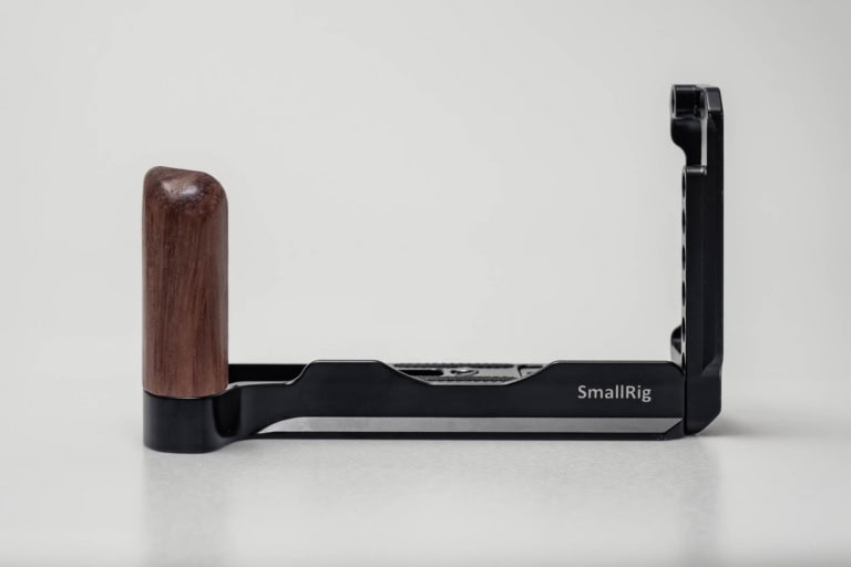 SmallRig L-bracket with wooden grip viewed from the side against a plain light gray studio background.
