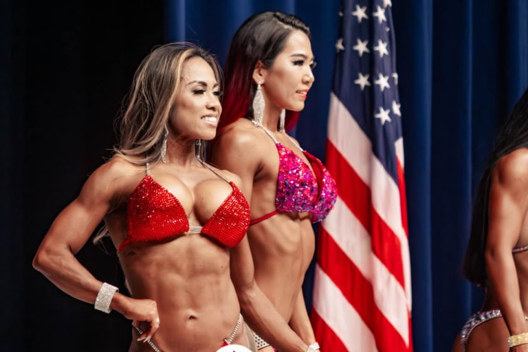Japanese female bikini competitors pose before a Japanese flag at Yokota Airbase’s Taiyo Recreation Community Center.