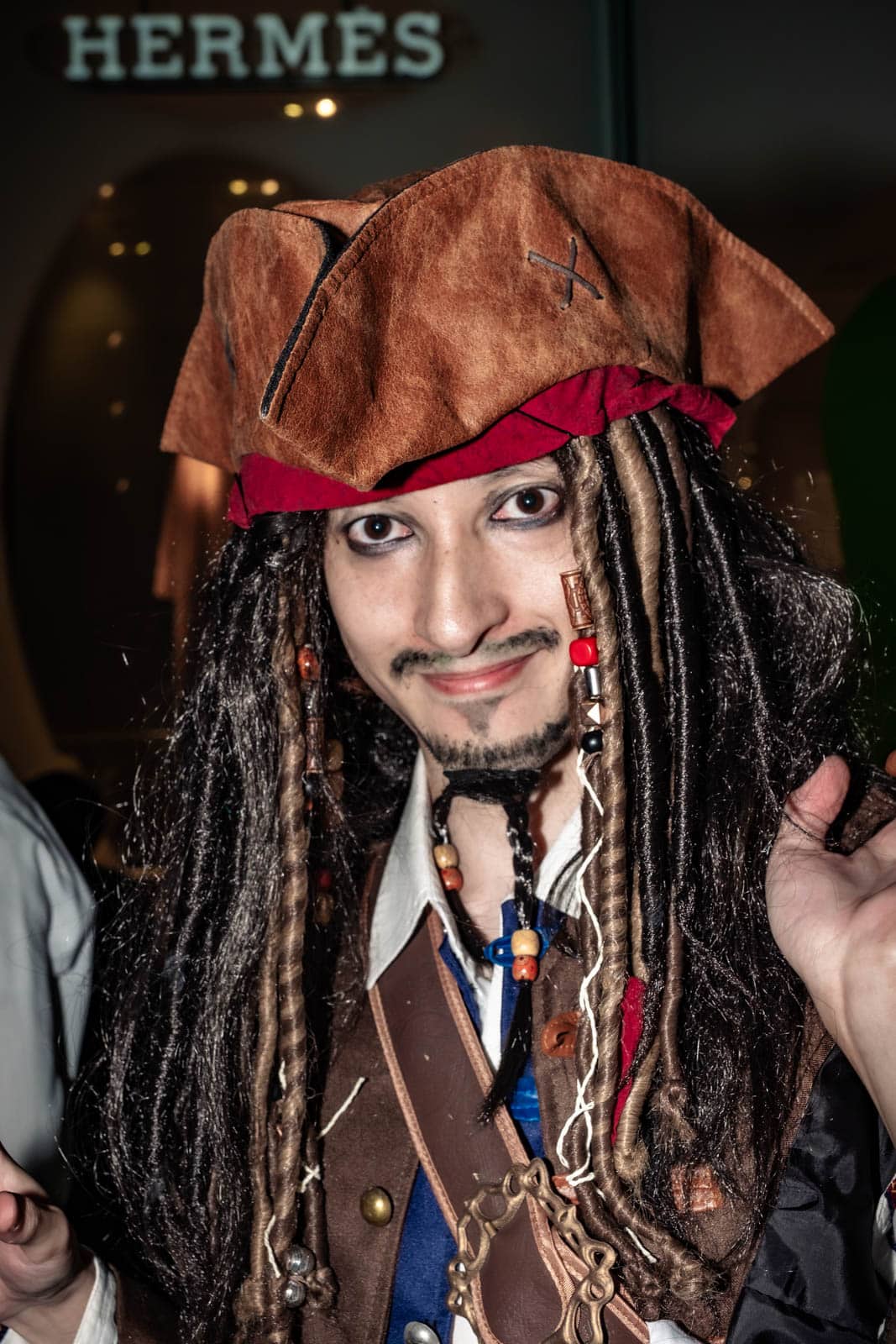 A Japanese man cosplaying as Captain Jack Sparrow complete with pirate hat and braids at Shibuya Halloween 2019.