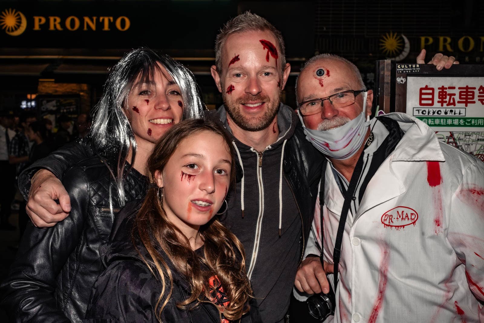 Foreign tourists in Halloween costumes celebrating in Shibuya at night.