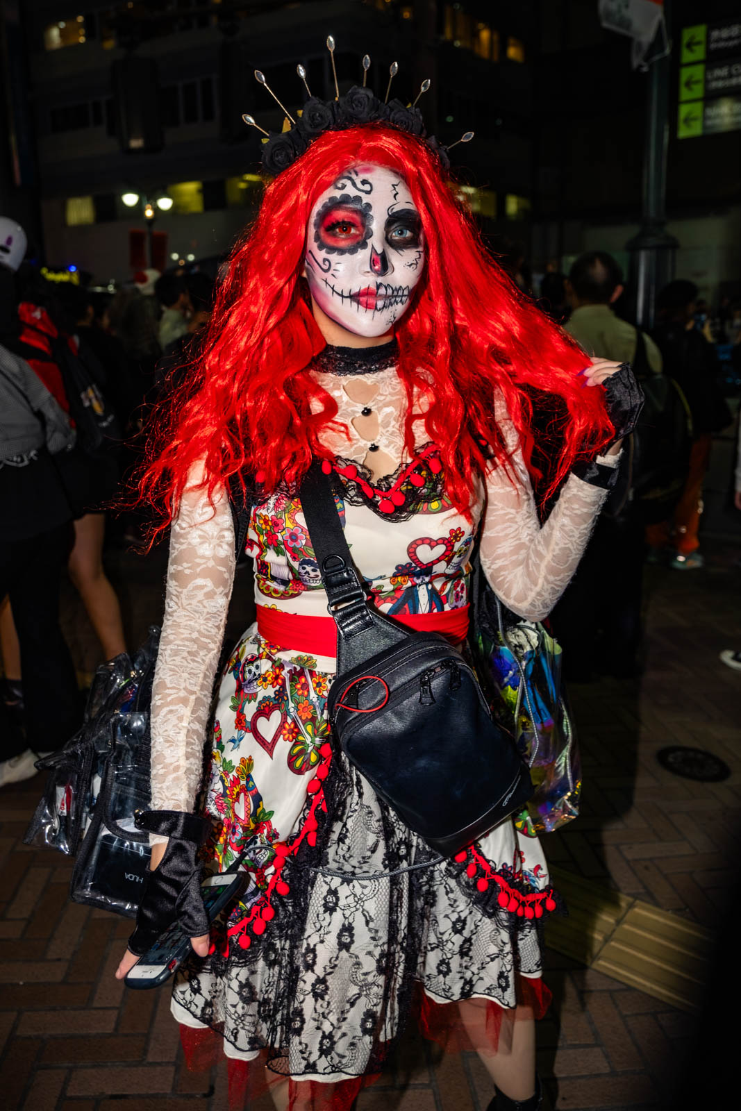 Woman in a Day of the Dead sugar skull makeup costume during Halloween in Shibuya.