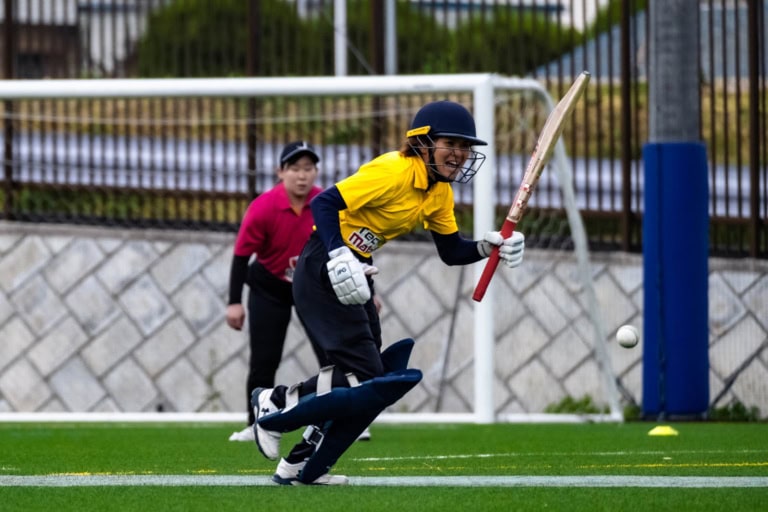 Shizuka Miyaji running between wickets while holding a cricket bat during a J-BASH match in Kanagawa.