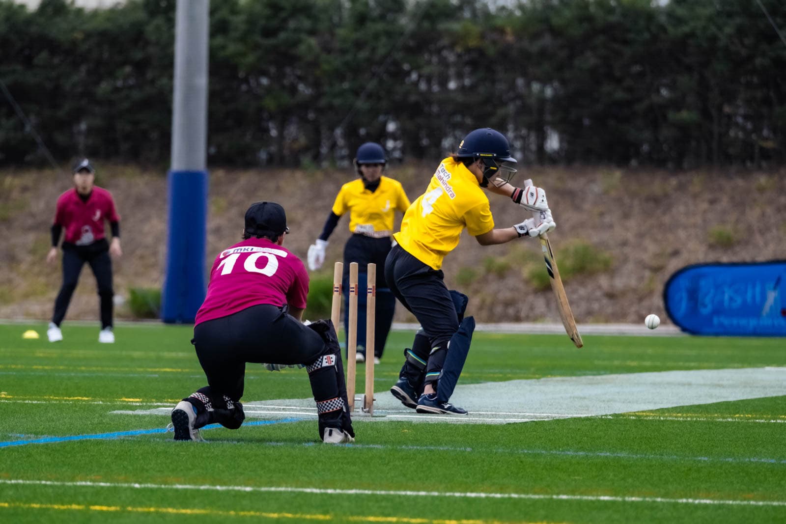 A female batter plays a defensive shot during a Japanese Cricket Association game.